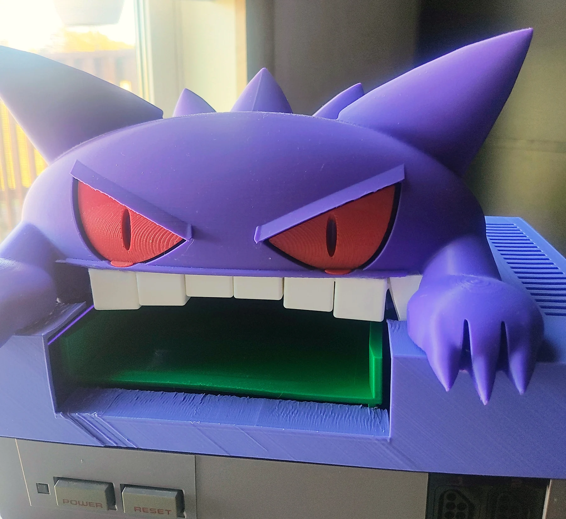 October 6, 2026 · A close view of the eyes, teeth, front opening, and visible print texture. Work in progress. The finished lid is not for sale; the $20 print-file bundle includes the all-in-one topper and structural NES lid/deck. Lid and console are not included in the connector kit.