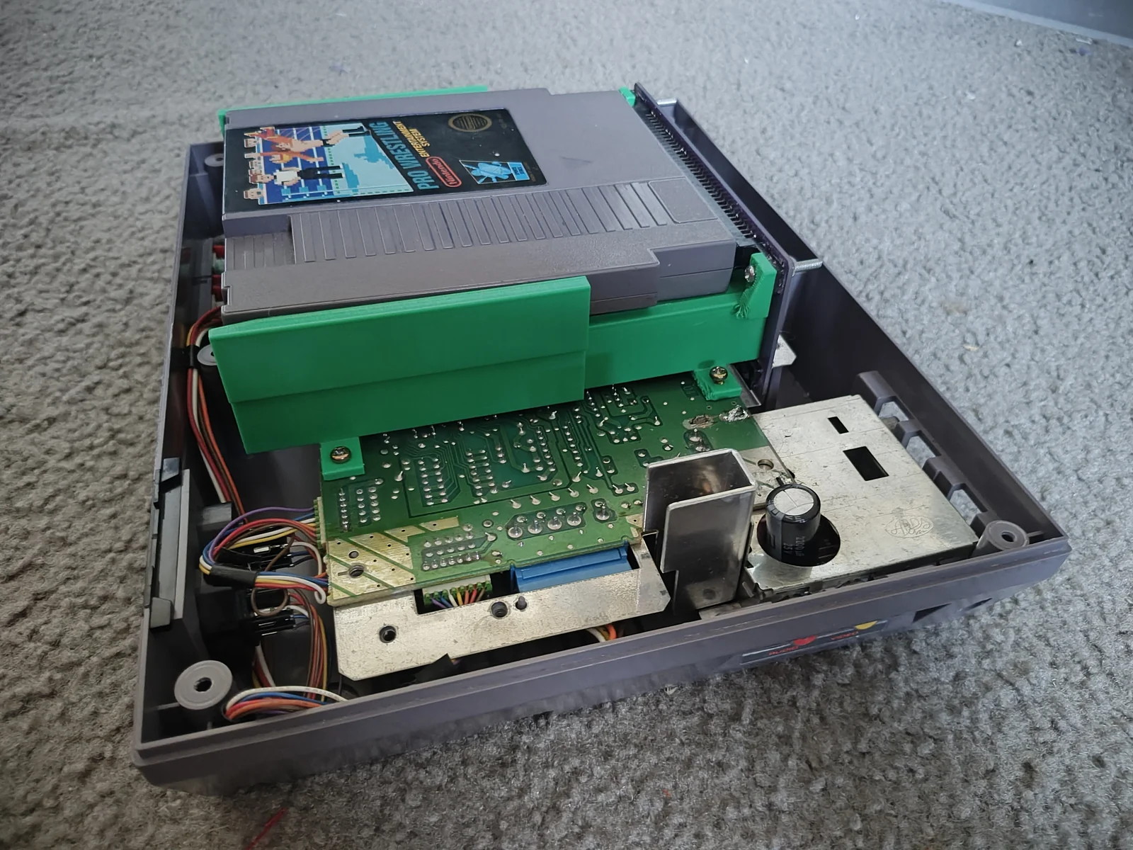 October 9, 2026 · Angled view of the green printed tray, purple board, and cartridge inside the open console. Final tests pending.